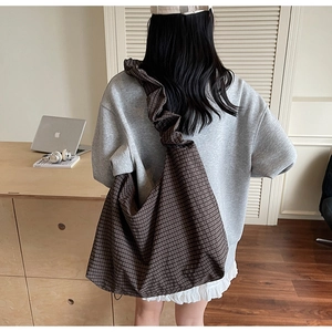 Détail du sac hobo avec tissu à carreaux marron foncé et large bandoulière à volants plissés
