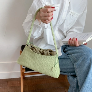 Detail der hellgrünen gewebten PU-Schultertasche mit praktischem Kordelzug-Innenfach