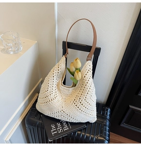Details der cremefarbenen Häkel-Tasche mit einem braunen Schulterriemen aus Leder