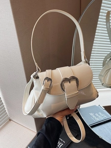 Chic beige patent leather saddle bag with heart-shaped metal buckle and adjustable strap