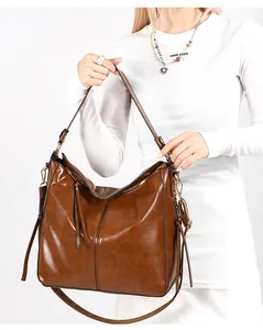 Dettaglio della borsa a secchiello vintage marrone scuro con nappa e tracolla regolabile