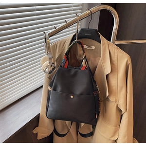 Détail du sac en nylon noir étanche avec broderie florale et sangles tissées colorées