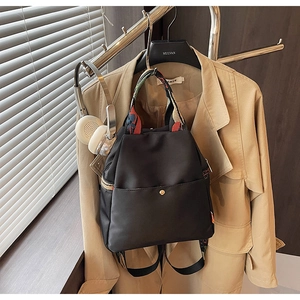 Détail du sac en nylon noir imperméable avec sangle ethnique colorée et boucle dorée