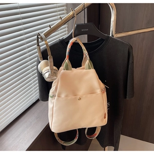 Vue détaillée du sac à dos beige imperméable avec bretelles colorées et boucle magnétique en métal