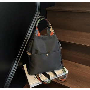 Détail du sac à dos noir imperméable avec poignée ethnique tissée colorée et boucle en métal