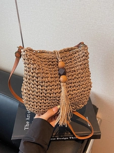 Borsa a secchiello in paglia intrecciata con tracolla in pelle e nappa per la spiaggia