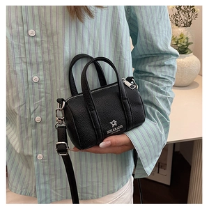 Detail of mini black lychee leather boston bag with silver logo and adjustable strap