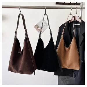 Close-up of matte suede tote bags in dark brown, black, and caramel with adjustable straps