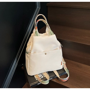 Détail d'un sac ivoire avec bandoulière brodée style ethnique sur un escalier en bois