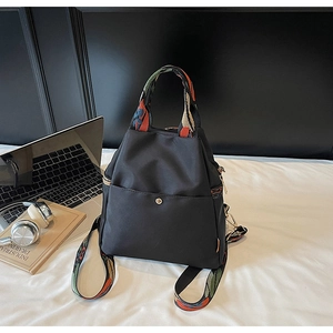Détail macro du sac à dos en nylon noir étanche avec bretelles tissées colorées