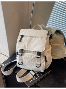 Cream white canvas backpack with multi-pocket design and buckles for outdoor travel