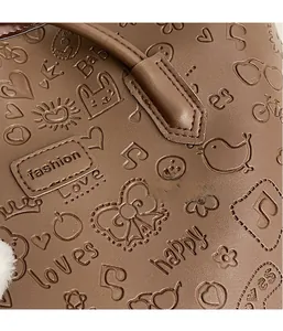 Dettaglio di borsa tote in pelle marrone scuro con motivi a rilievo e texture moda