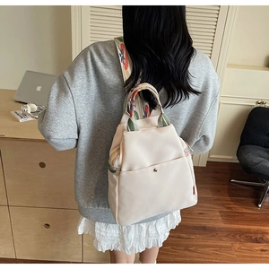Détail du sac à dos blanc cassé avec bretelles tissées style ethnique et poches à pression