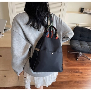 Détail d'un sac à dos en nylon imperméable avec large bandoulière brodée ethnique