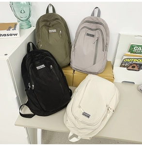 Close-up of durable canvas backpacks in four colors with multi-pocket design detail
