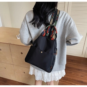 Détail d'un sac à dos en nylon imperméable avec bretelles colorées aux motifs ethniques