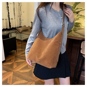 Detail of caramel frosted leather hobo bag with adjustable wide strap and gold hardware