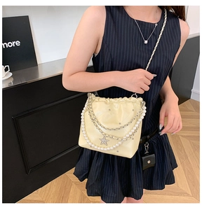 Détail du sac seau matelassé crème avec chaîne en perles et pendentif en forme d'étoile