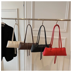 Woven underarm bags displayed in cream, brown, black, and red with fringe details