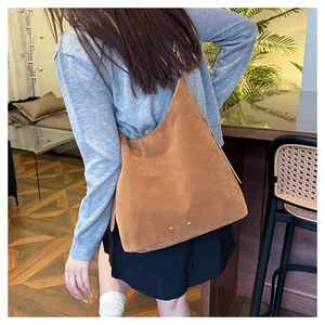 Brown vintage suede bucket bag shown on model highlighting its large size and soft texture
