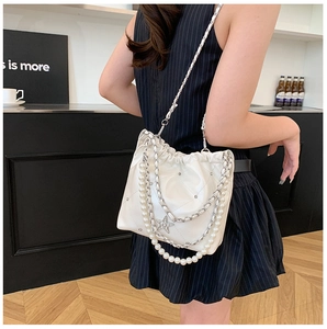 Détail du sac seau blanc à cordon avec chaîne perlée et pendentif étoile sur mannequin