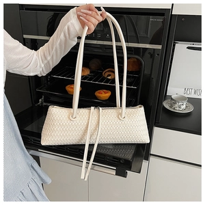 Detail of cream woven shoulder bag with fine leather texture and dual zipper pulls