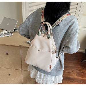 Détail du sac à dos en nylon blanc cassé avec bretelles brodées style ethnique