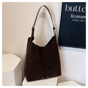 Close-up of vintage dark brown matte suede hobo bag with adjustable metal buckle on shoulder strap