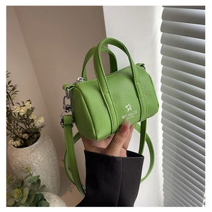 Detail of green litchi grain barrel bag with MISU & MADER logo and adjustable strap