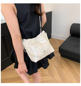 Détail du sac seau blanc en cuir matelassé avec bandoulière perle et breloque en étoile