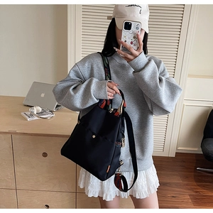 Détail du sac à dos en nylon noir étanche avec bandoulière brodée de style ethnique