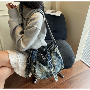 Detailed texture of stone-washed denim bag featuring metal eyelets and y2k buckle accents