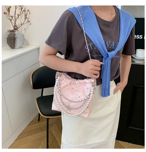 Détail du sac seau rose matelassé avec chaînes de perles et pendentif étoile de mer