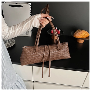 Close-up of deep brown woven leather texture and zipper detail on the baguette bag