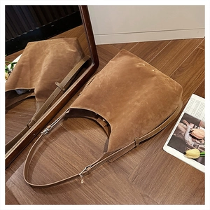 Detail of dark brown suede shoulder bag showing matte texture and adjustable leather strap