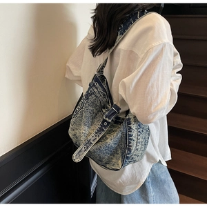Detail of blue denim tote bag showing washed vintage texture and metal eyelet strap