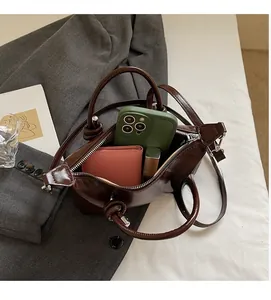 Detail view of spacious brown leather handbag interior holding phone and daily essentials
