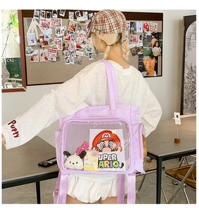 Detail of lavender ita bag featuring clear PVC window display and Super Mario theme charm