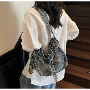 Detail of adjustable metal eyelet strap on vintage washed denim tote bag for women
