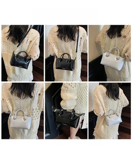 Detailed view of minimalist knot handle handbags in black and beige faux leather
