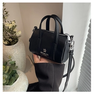 Detail of black pebbled leather mini Boston bag featuring star logo and silver hardware