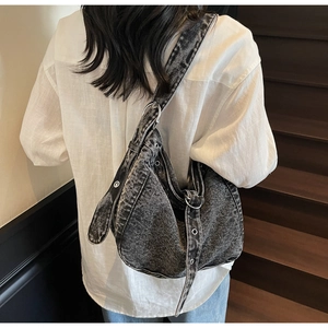 Detail of adjustable vintage metal eyelets and buckles on the denim tote shoulder bag