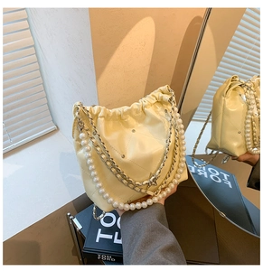 Détail du sac seau matelassé jaune crème avec chaîne en perles et pendentif étoile