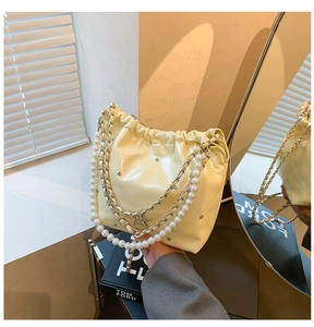 Détail du sac seau matelassé crème avec poignée en perles et pendentif étoile