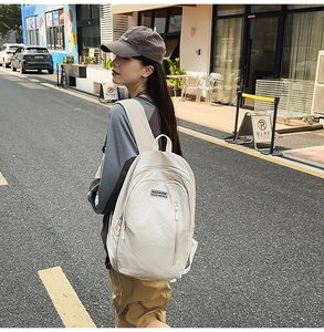 Cream canvas backpack on model showing a large capacity design in an urban street setting