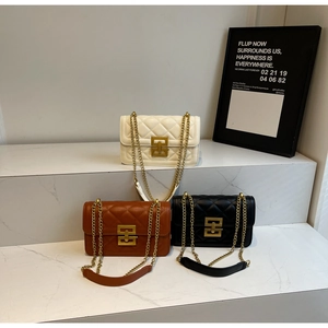 Détail de sacs à bandoulière matelassés en crème, marron et noir avec chaîne dorée