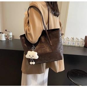 Borsa tote marrone in pelle con motivi a rilievo e ciondolo a nuvola sulla modella