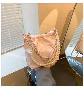 Vue détaillée du sac seau matelassé rose avec chaîne en perles et breloques étoiles