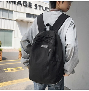 Detailed view of black nylon backpack with brand logo and water-resistant fabric
