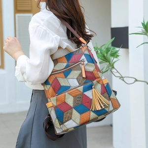 Detail of the multi-color geometric 3D cube pattern and fringe charm on the backpack